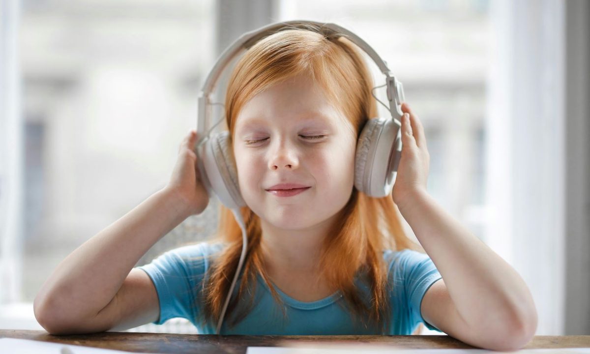 Young girl listening to podcast on headphones