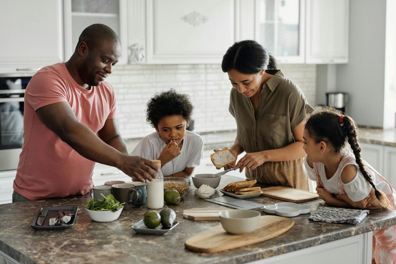 Parents and kids having fun in the kitchen making breakfast