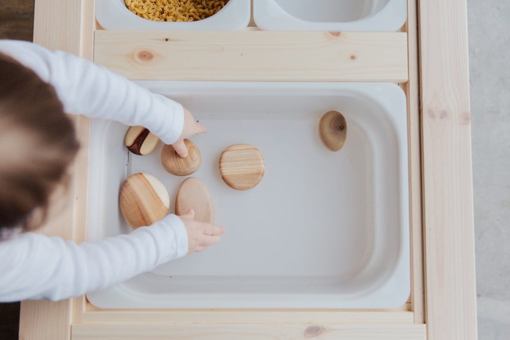 child playing in pretend kitchen sink