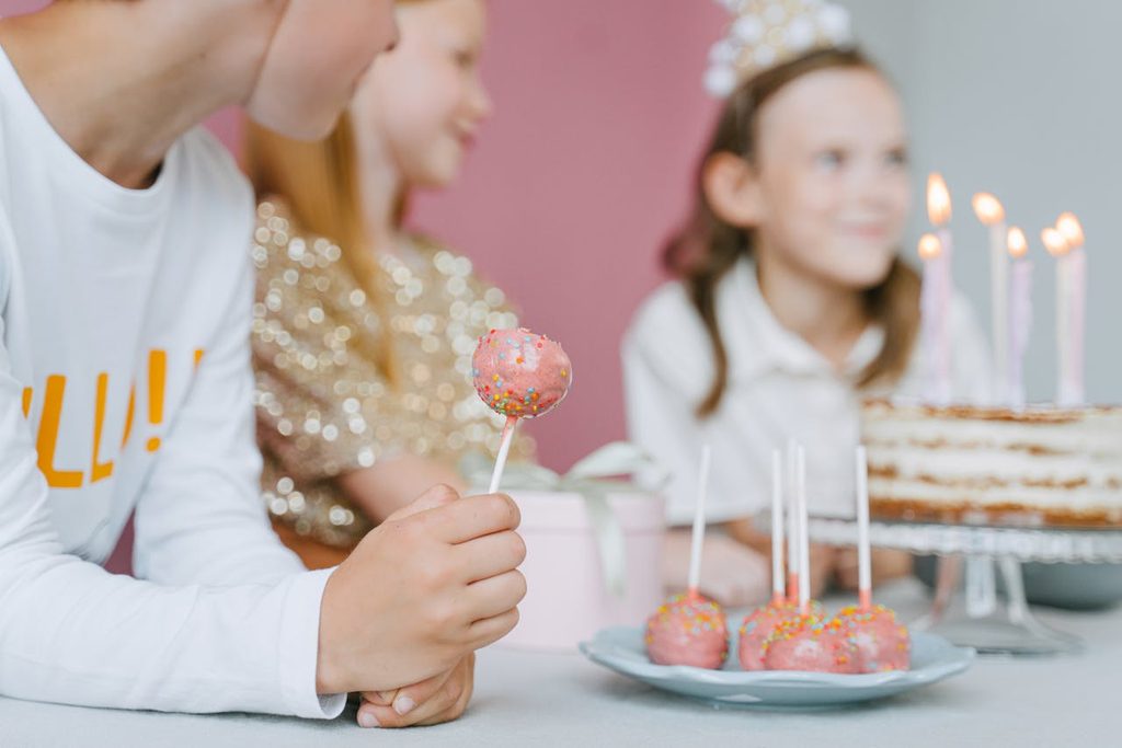 Kids eating cake pops at a birthday party.
