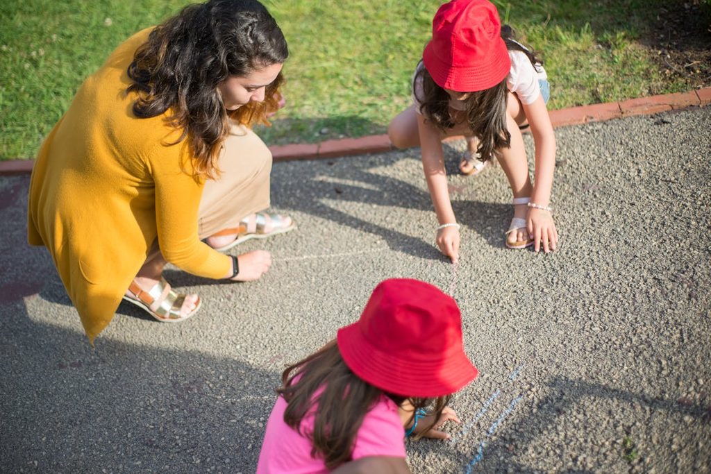 A caretaker playing with the kids outside.