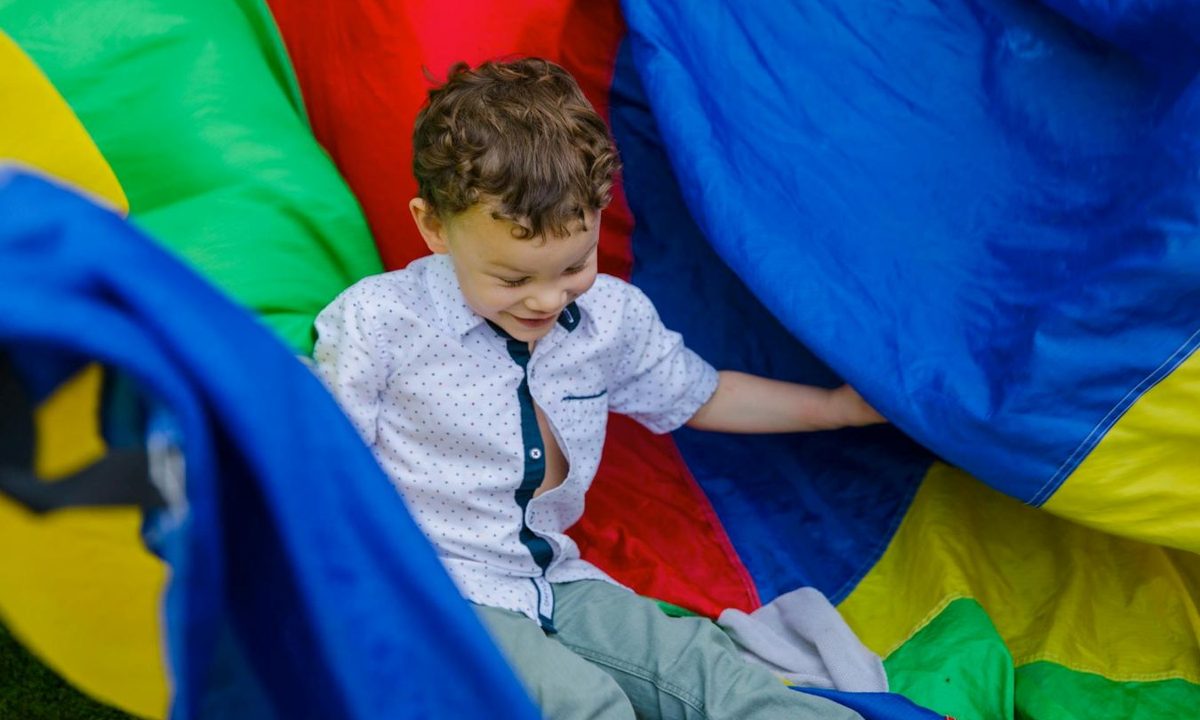 boy playing on a parachute at summer camp