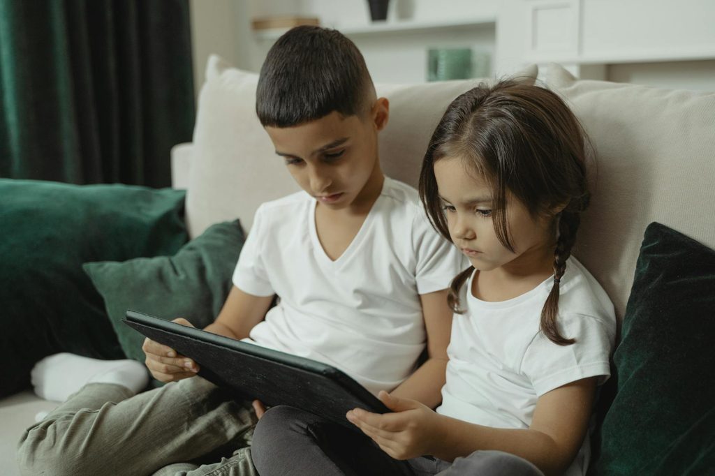 Two children looking at a tablet.