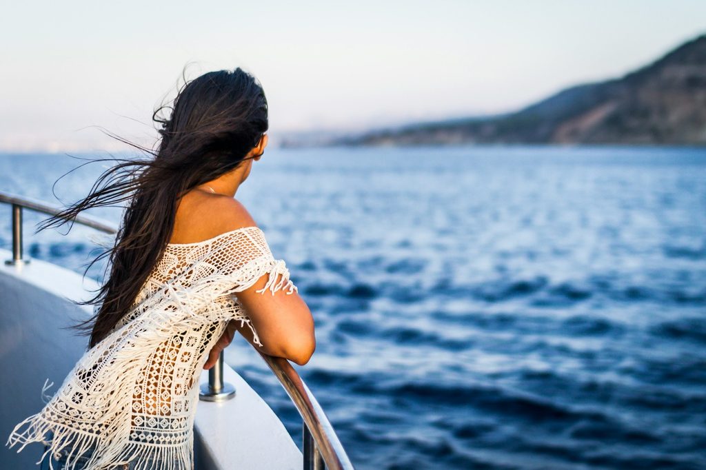 A female looking over the side of a cruise ship.