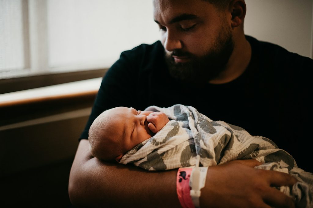 A dad holding a newborn baby.
