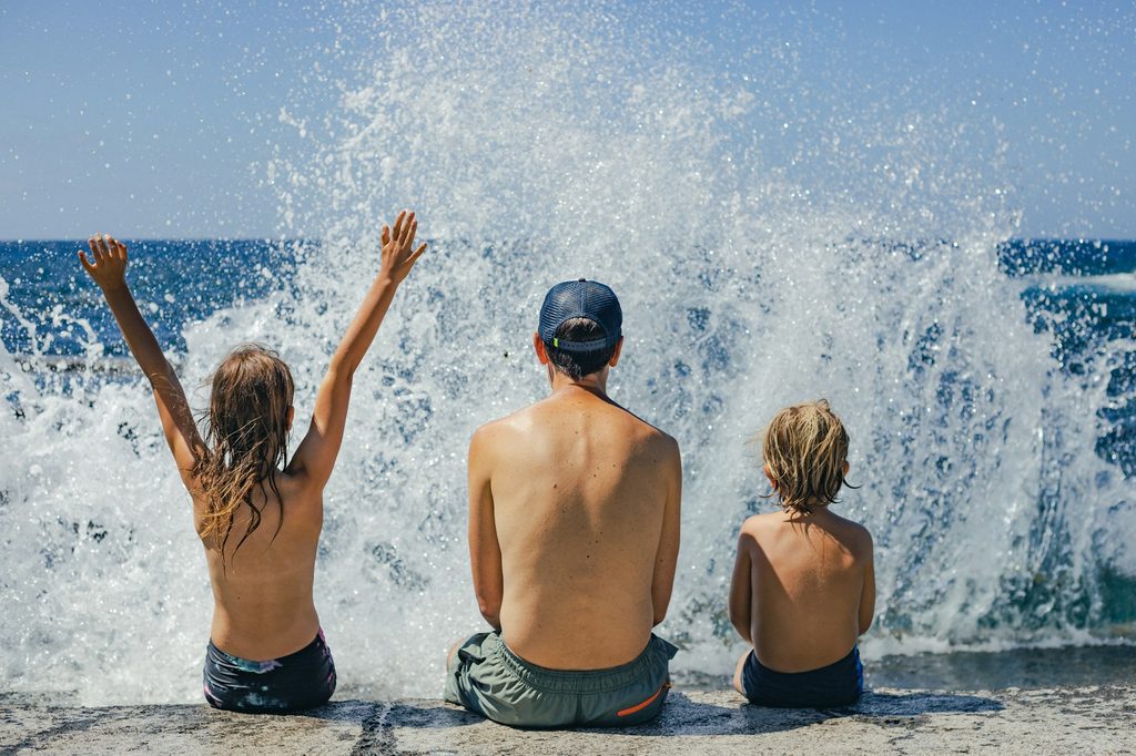 A parent and kids enjoying the water on vacation.