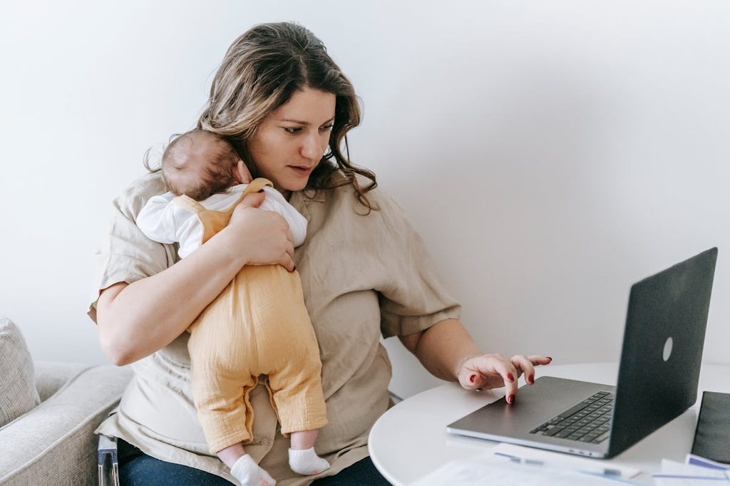 mom holding baby on computer