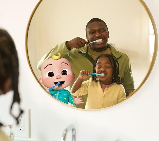 Dad brushing teeth with daughter and looking in the mirror with CoComelon