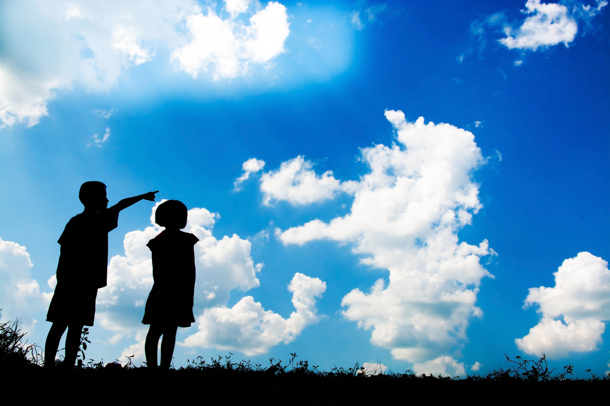 two kids looking up at cloud shapes