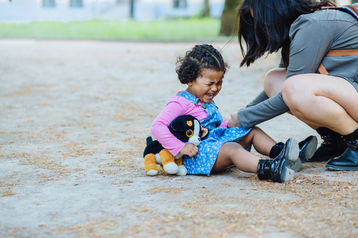 A toddler throwing a fit at a park.