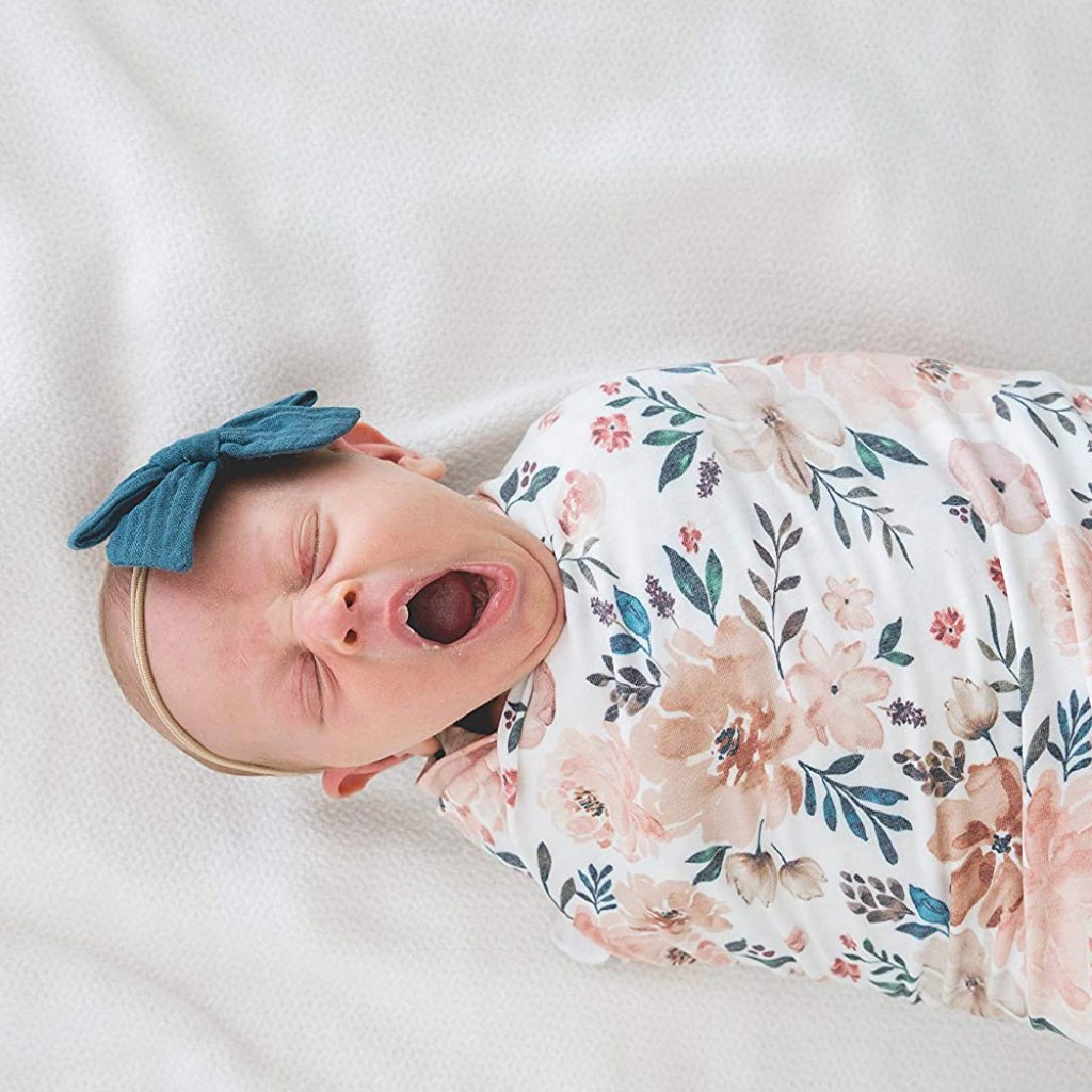 baby in swaddle blanket yawning