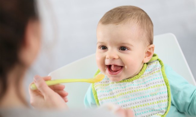 Woman feeding baby in a high chair