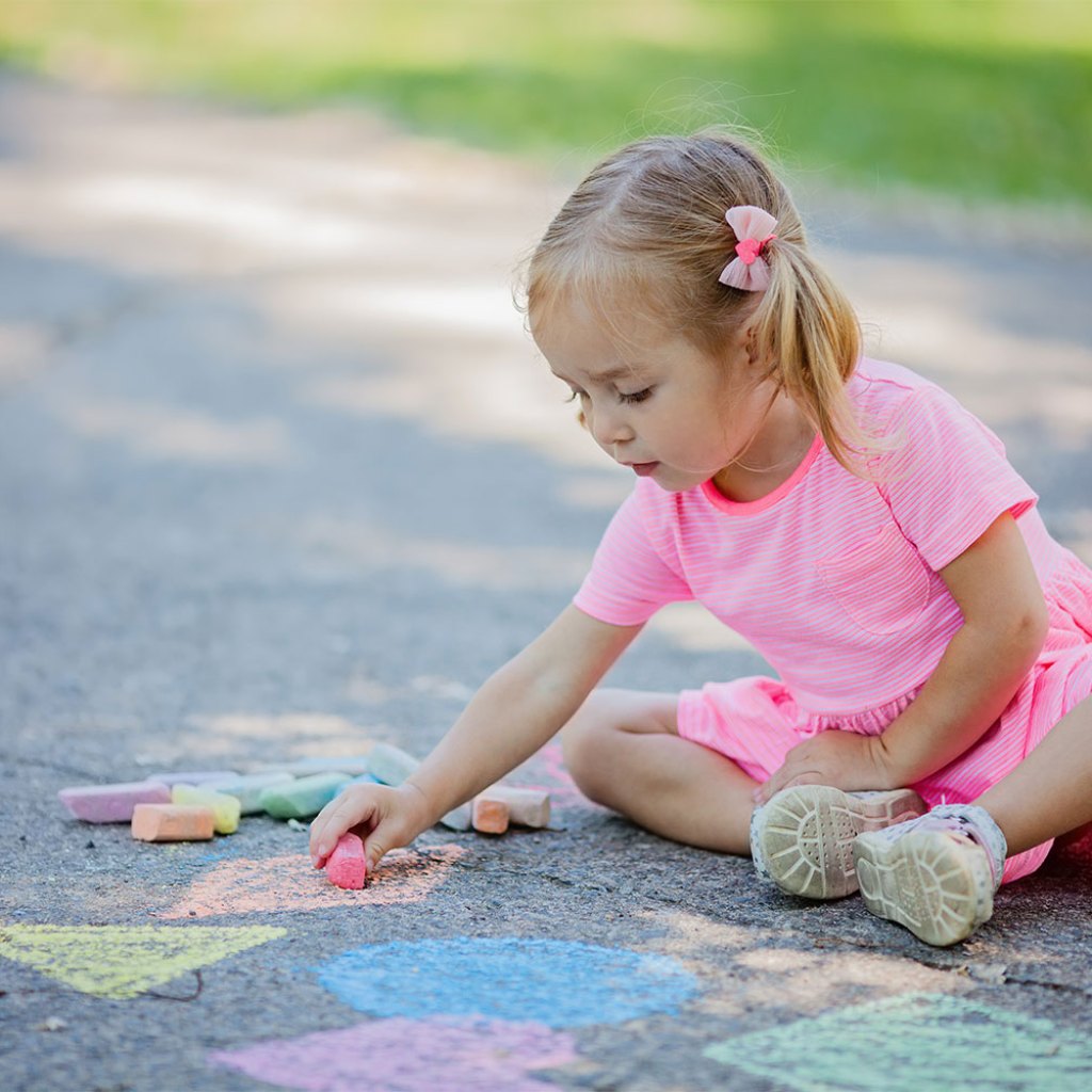 girl drawing on sidewalk