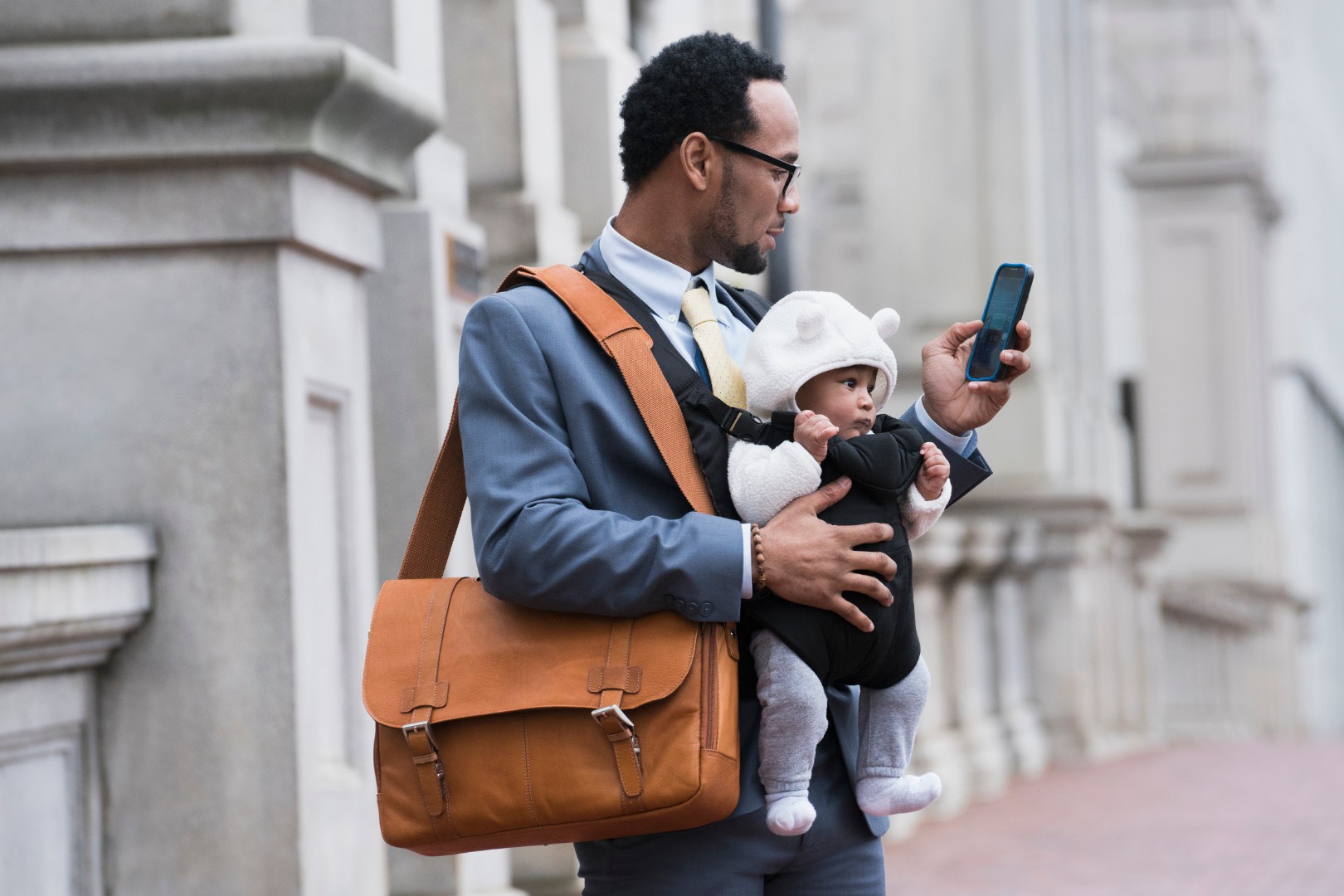 Adult with baby, bag, and phone