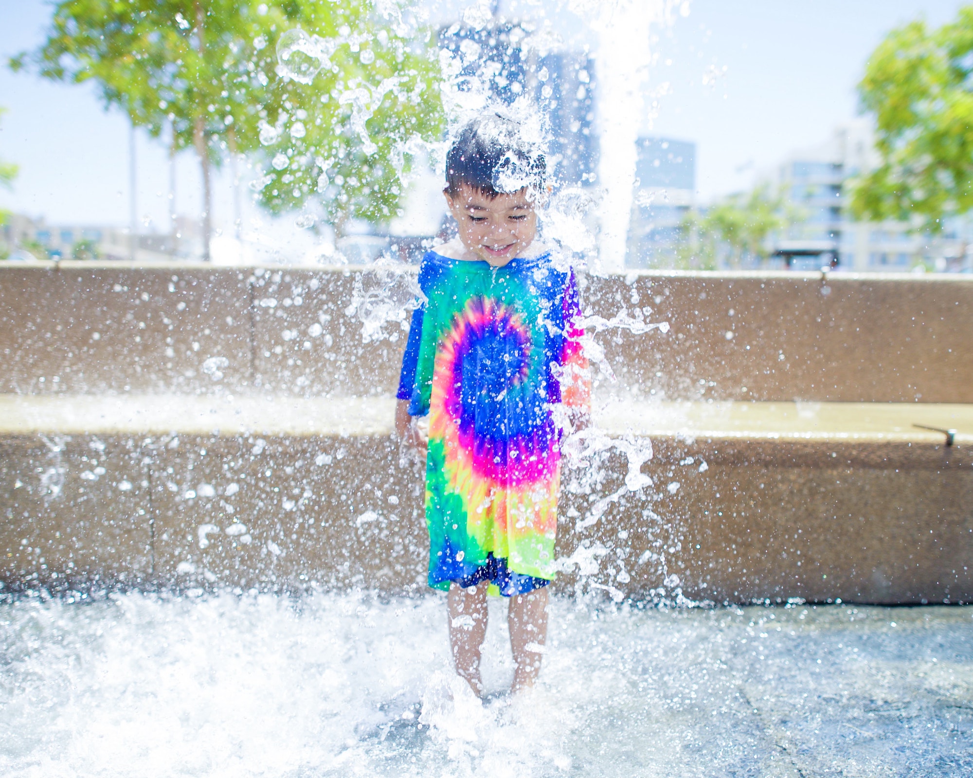 Boy wearing long shirt jumping in the water.