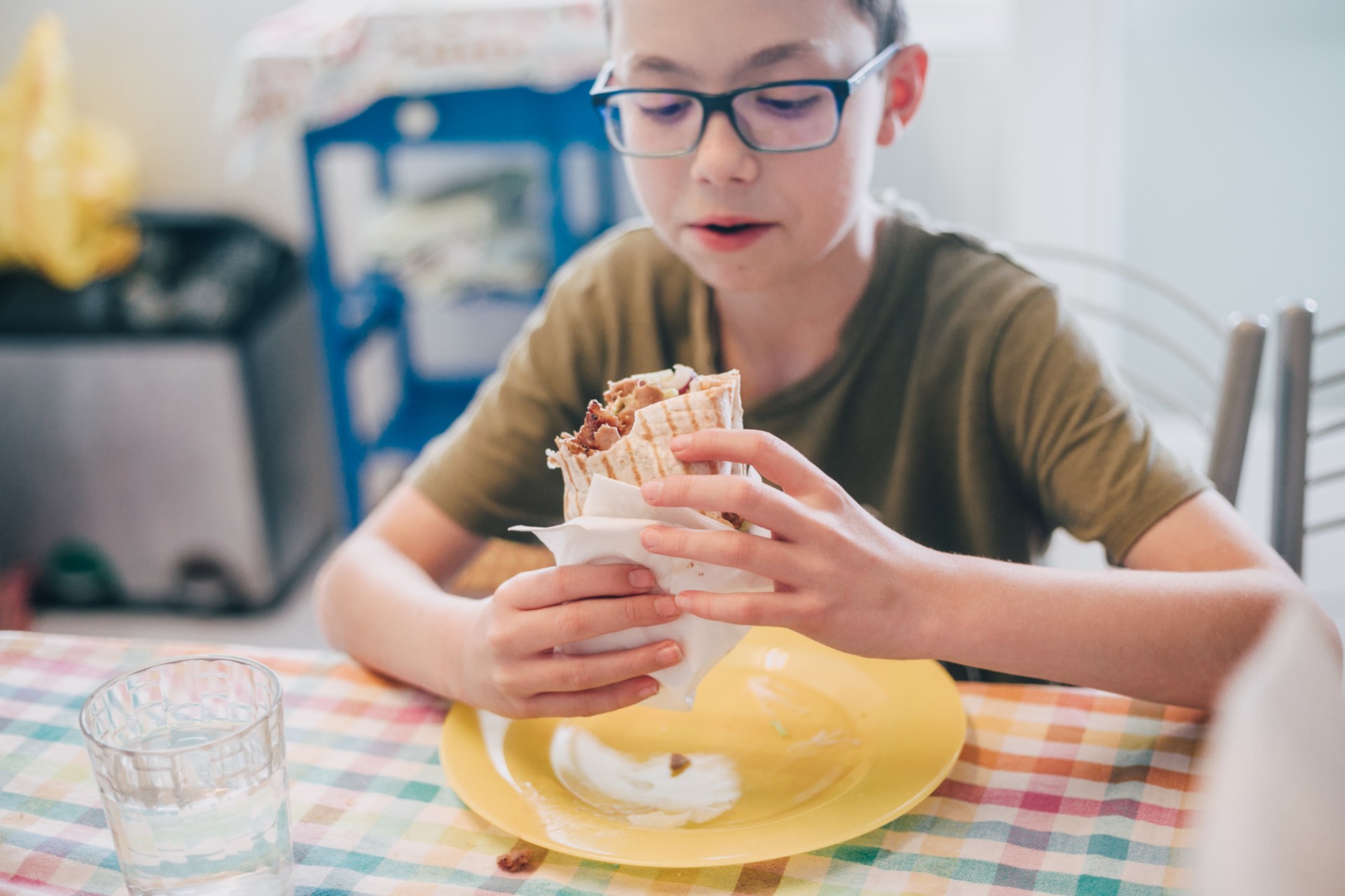 Young boy at table with chicken wrap