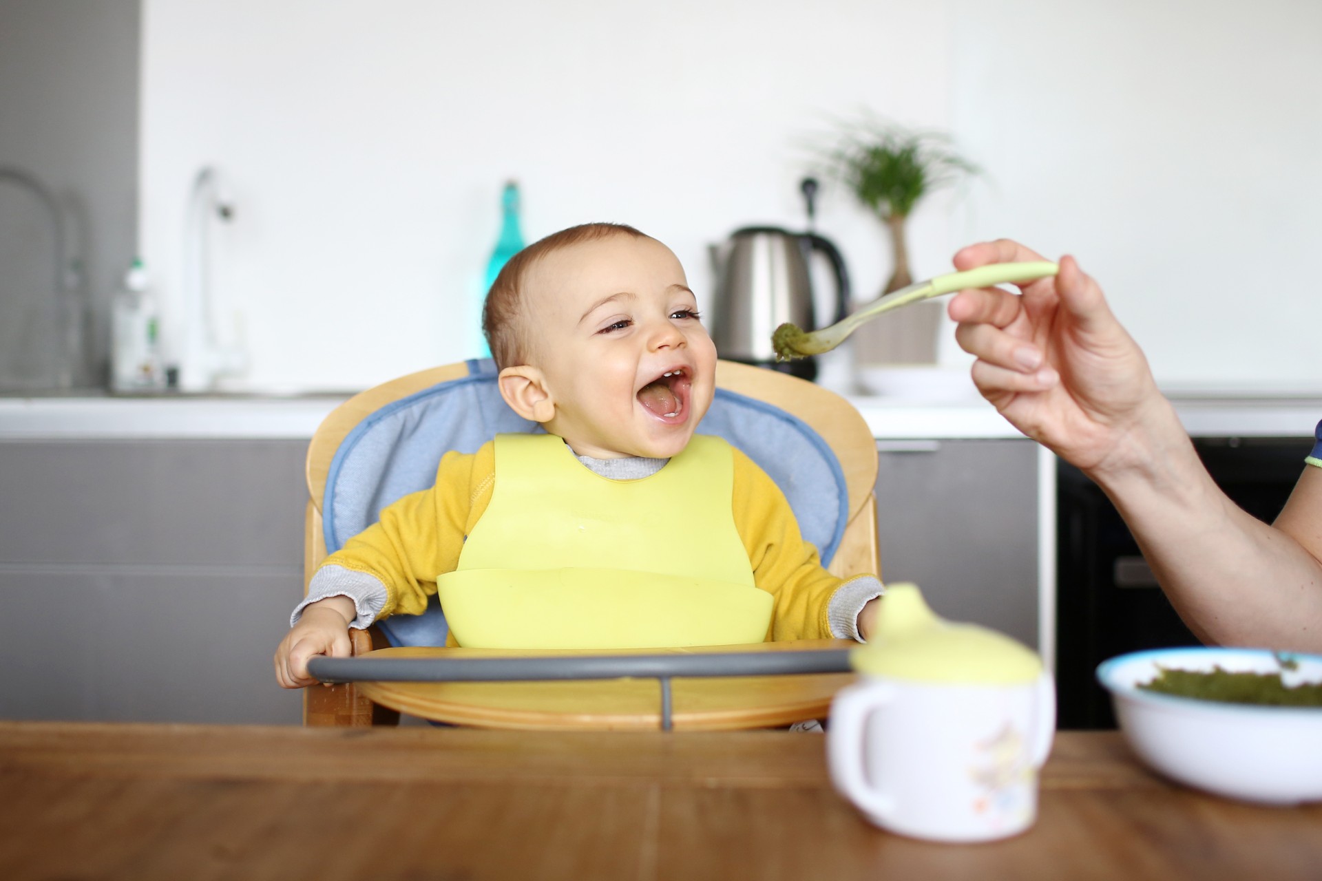 Happy baby in highchair eating