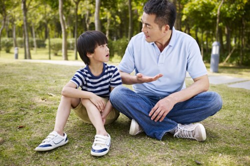 Father talking with son at park