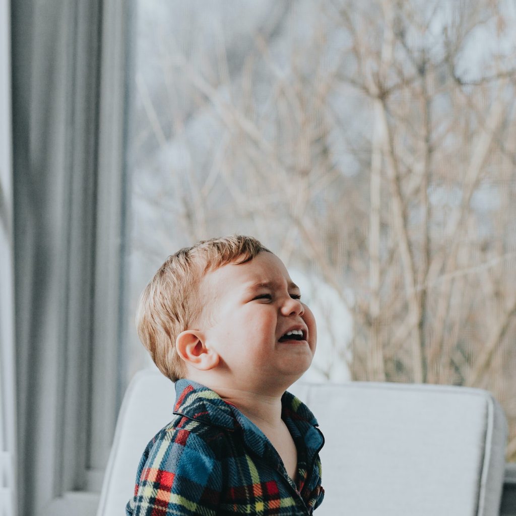 Child crying in a house by a window.