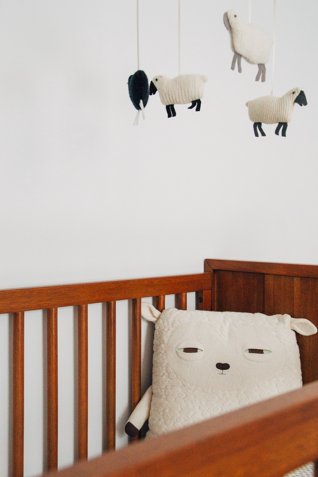 crib with sheep pillow and sheep mobile overhead