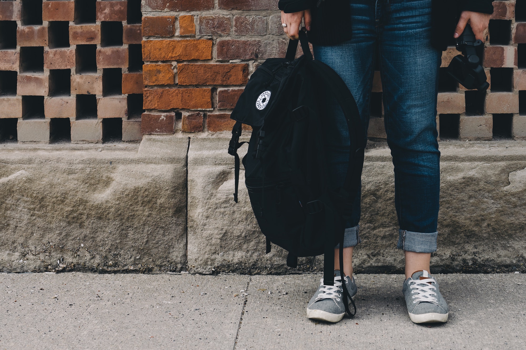 shot of student's jeans, sneakers and backpack