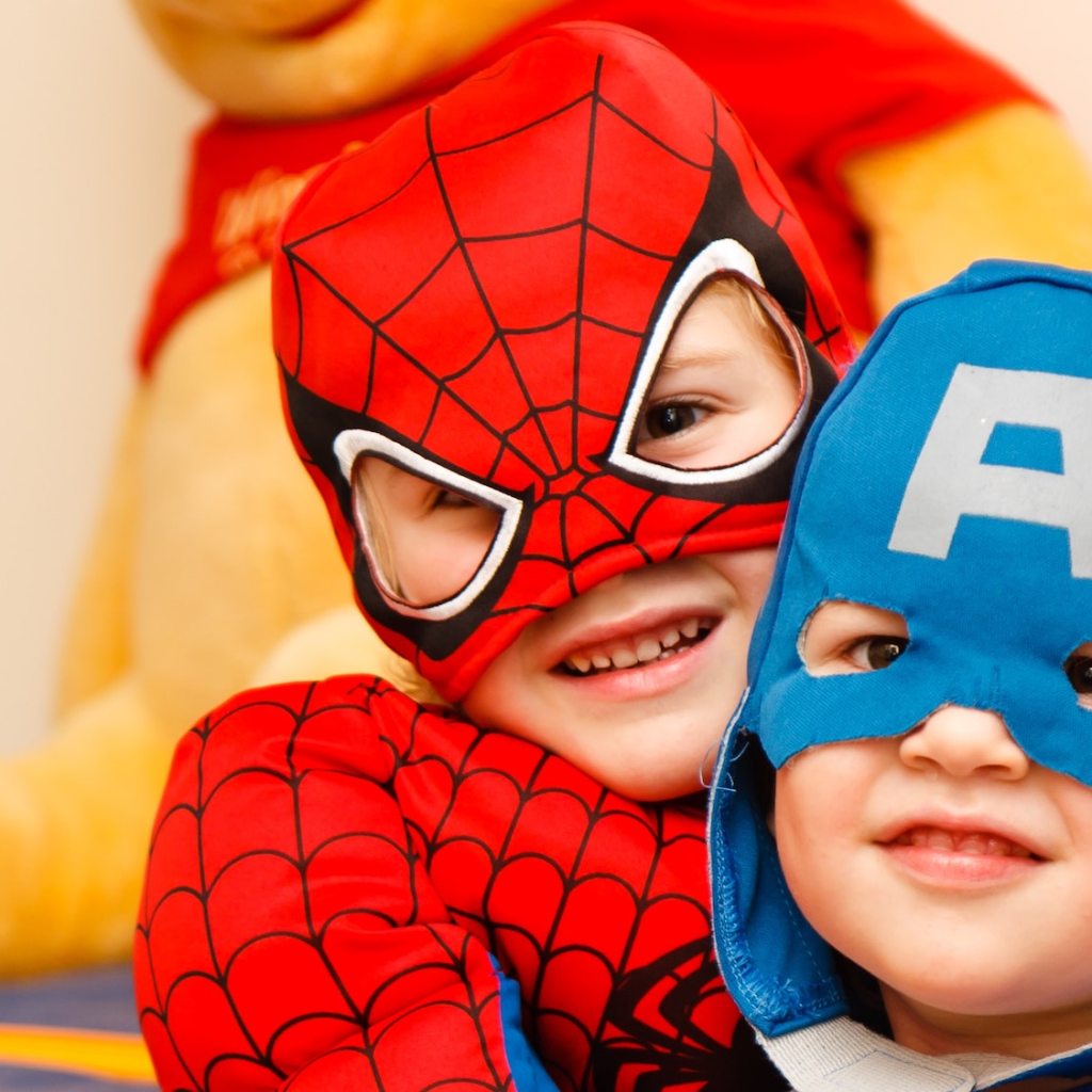 Two kids in superhero costumes