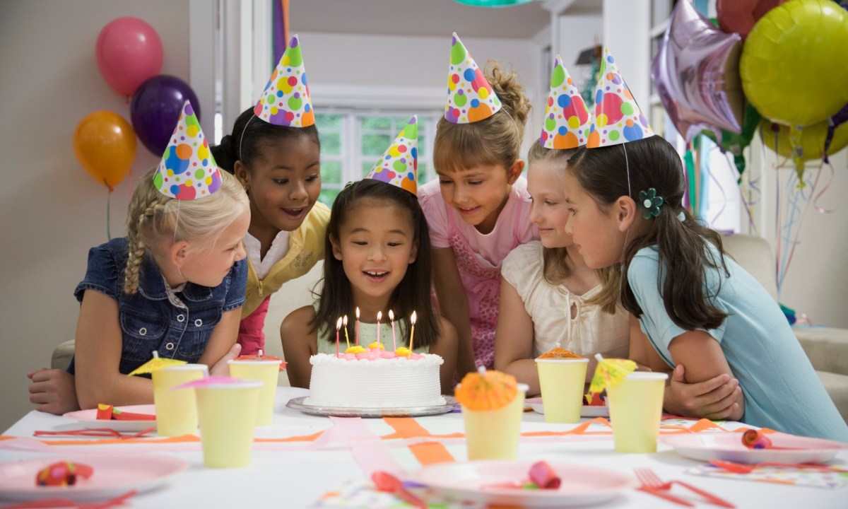Young girls celebrating a birthday with cake