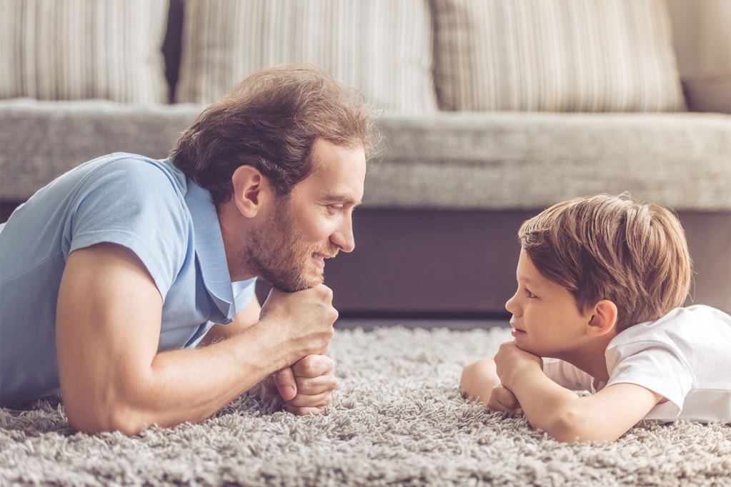 A child and parent on the floor talking.