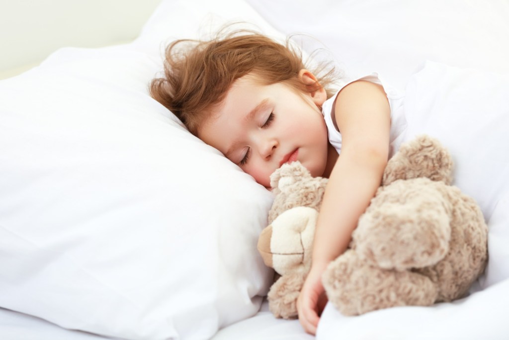 Toddler girl sleeping with plush bear