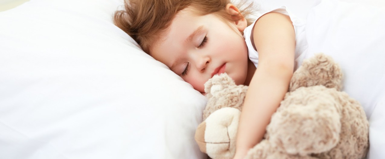 Toddler girl sleeping with plush bear