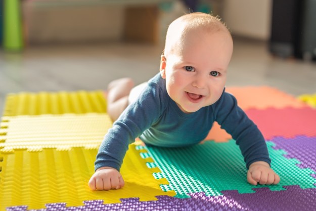 Smiling baby on colorful play mat