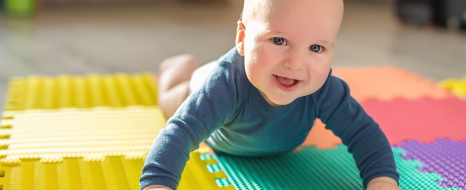 Smiling baby on colorful play mat