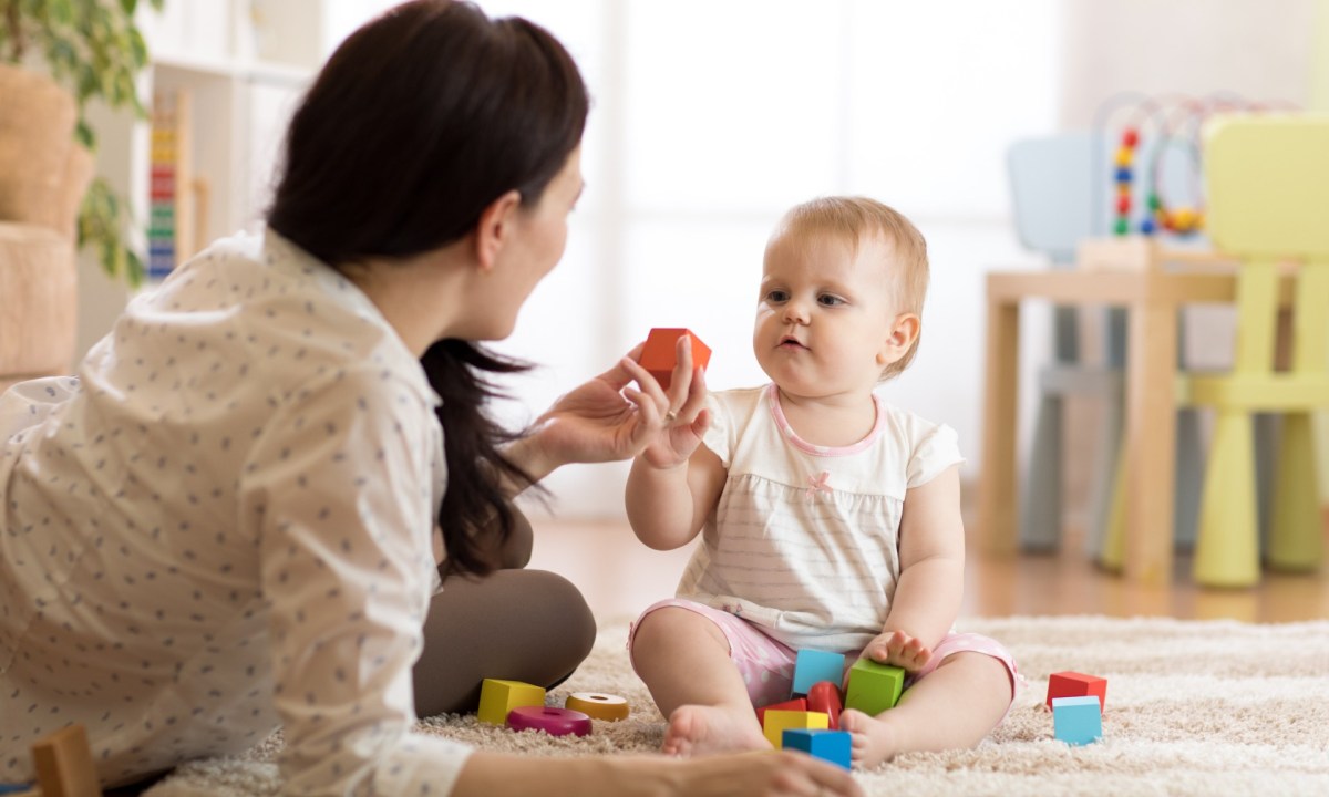 Mother with child playing with building blocks.