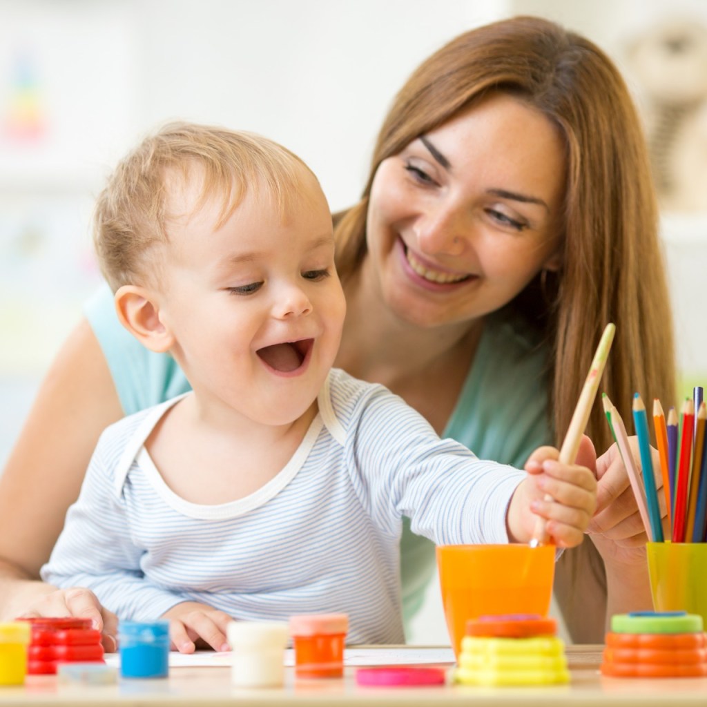 Mother with child using art supplies