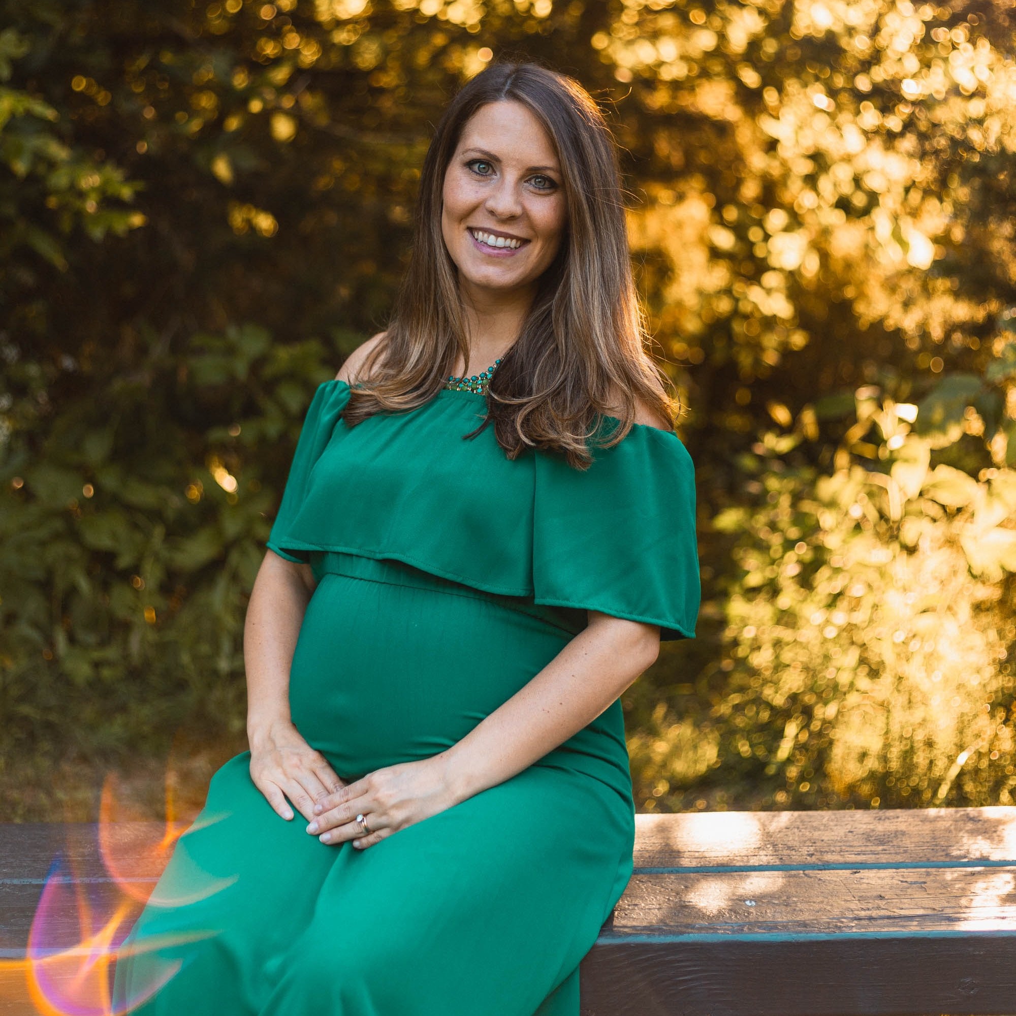 Pregnant woman smiling sitting outside