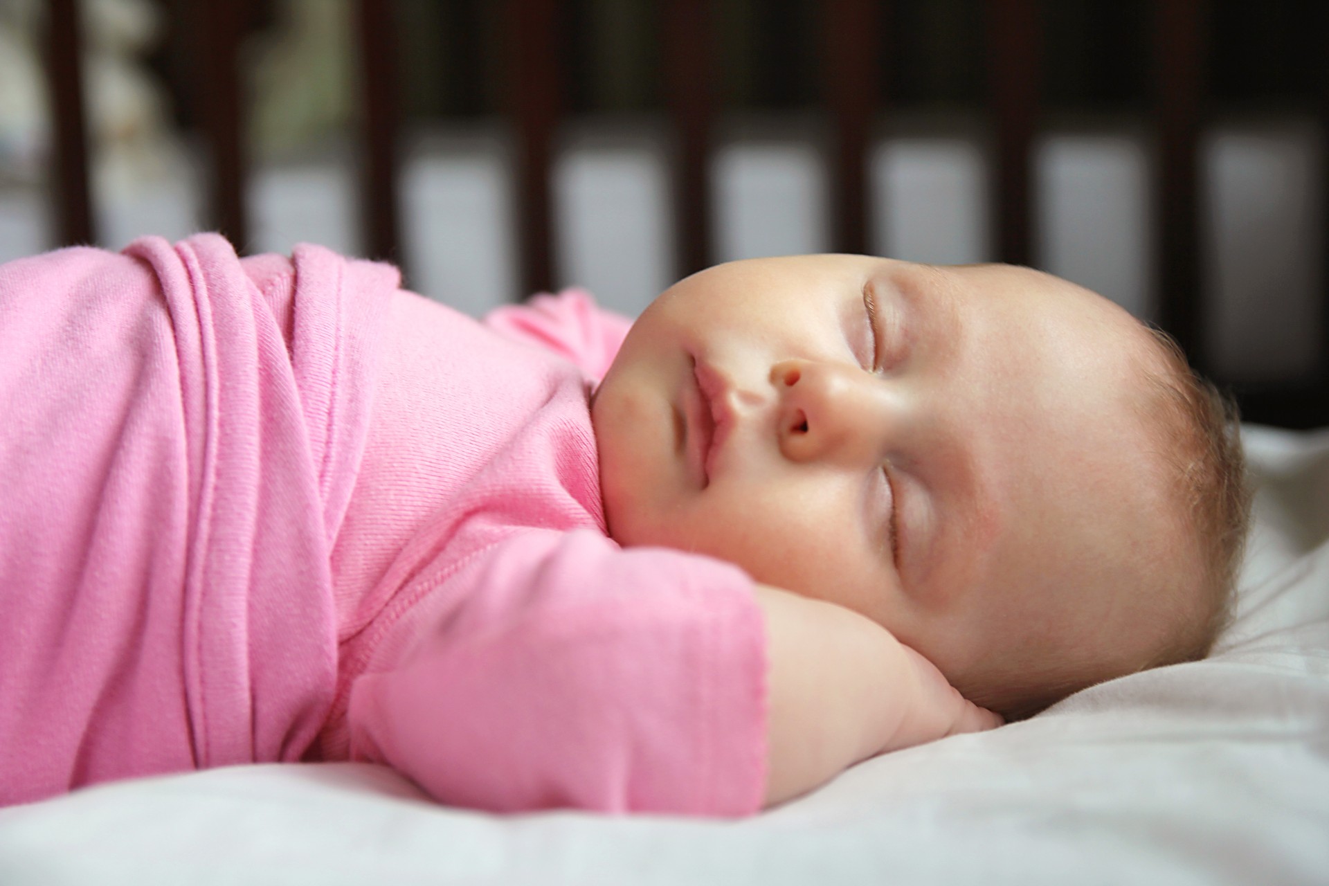 Infant girl sleeping in crib