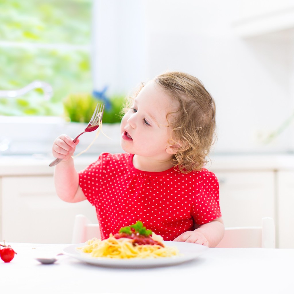 Young girl eating a plate of spaghetti