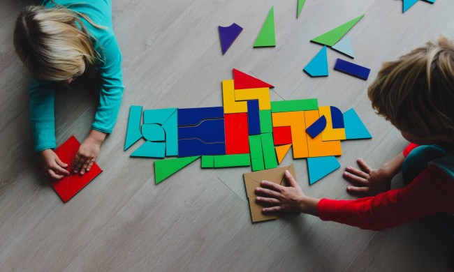 Two young kids playing with tangram puzzle