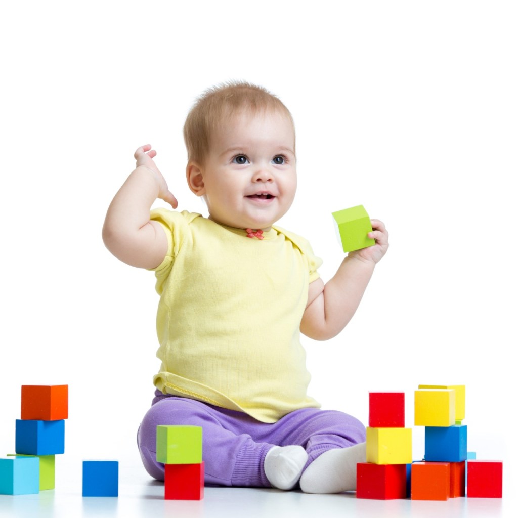 Baby playing with multicolored blocks.