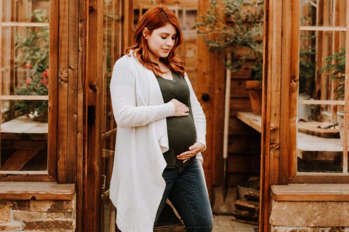 Pregnant woman standing in wooden sun room