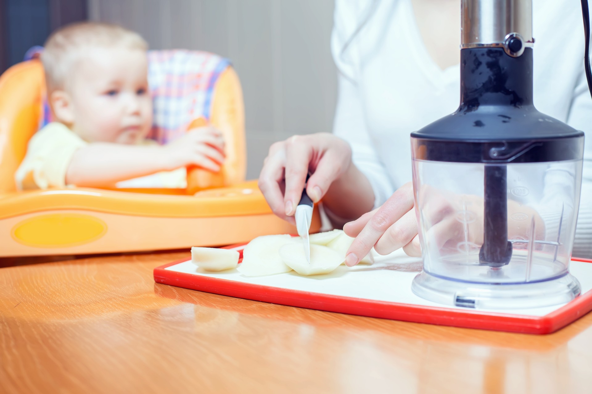 Mother preparing baby food for a blender
