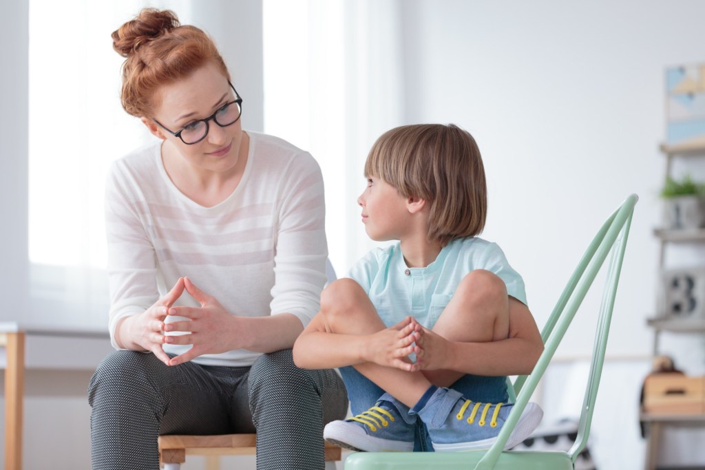 Mother talking with young son in living room