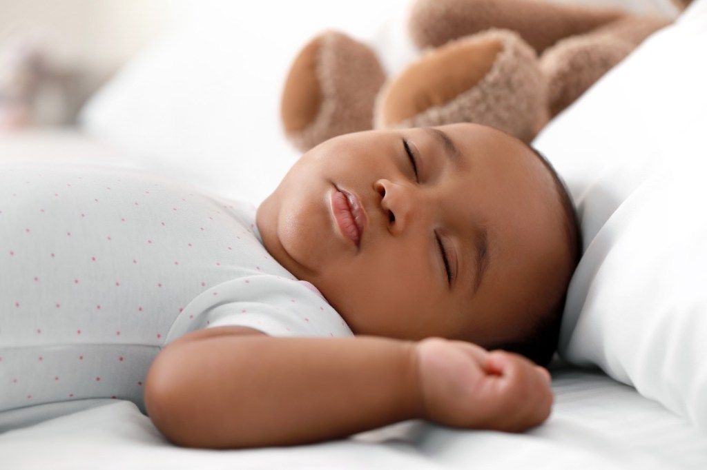 Infant boy sleeping on bed