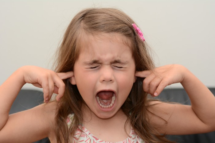 Young girl is screaming with fingers in her ears