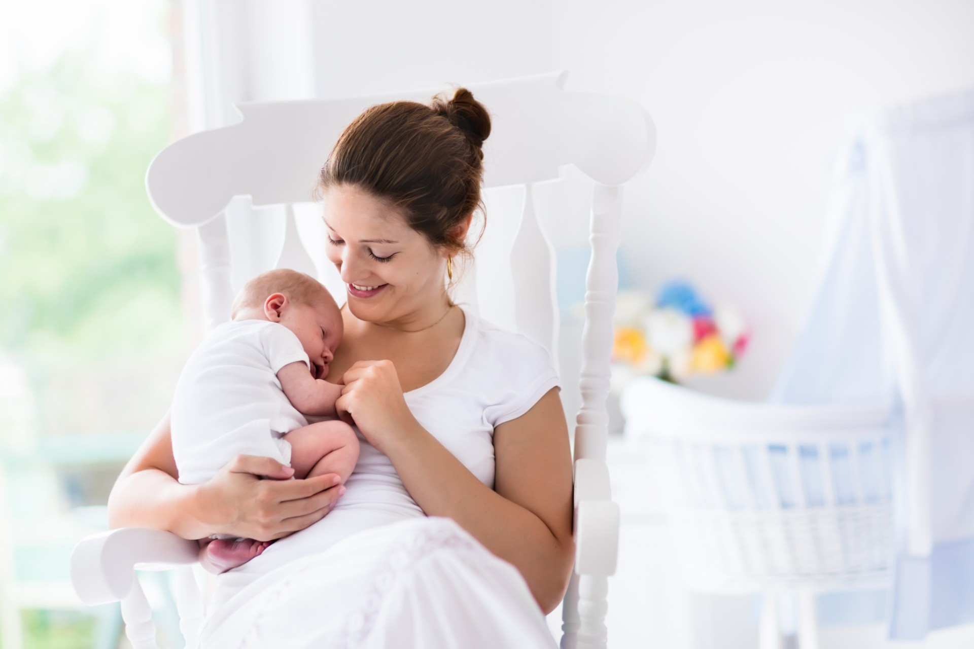 Mother holding baby in nursery.