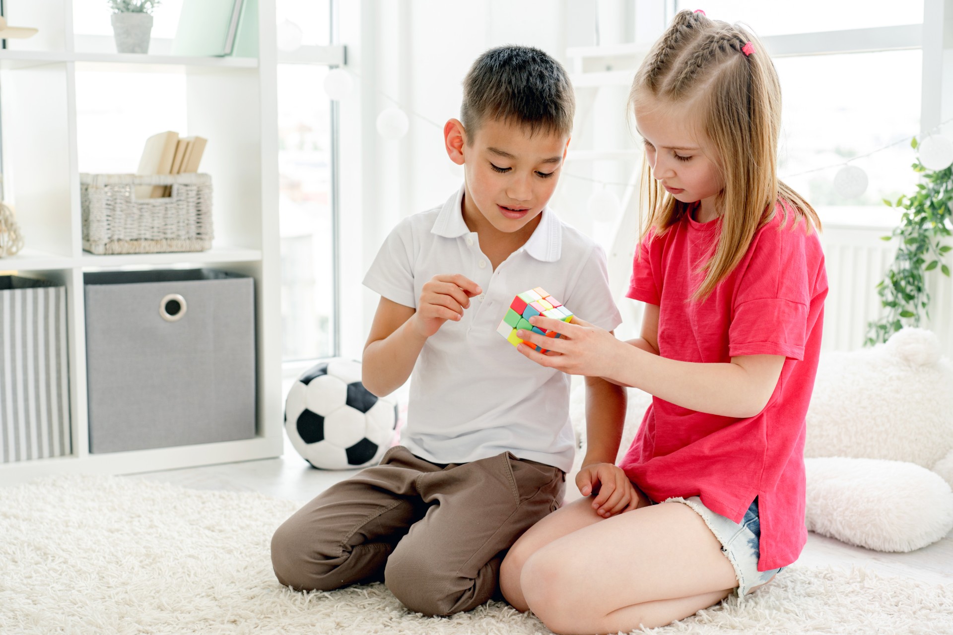 Boy and girl playing with a Rubik's Cube