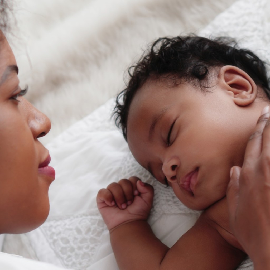 Mother lying next to sleeping toddler son.