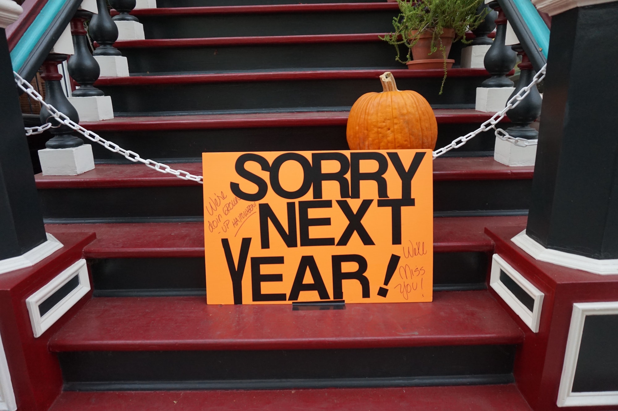 sorry next year sign with chain on doorstep on Halloween