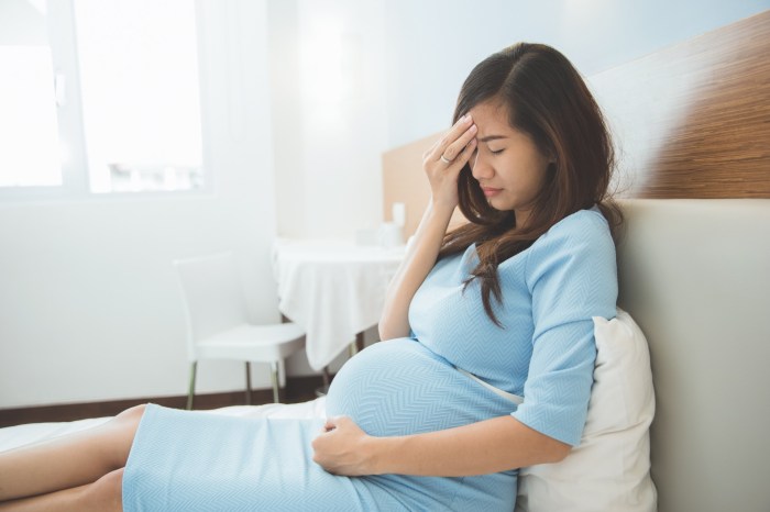 Pregnant woman on couch experiencing cramps