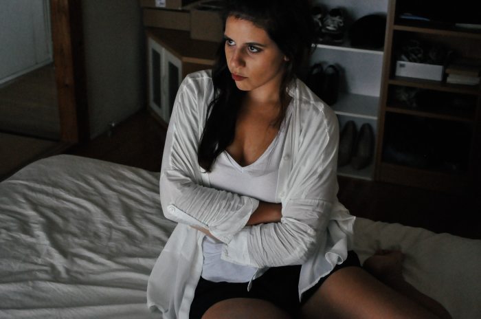 teenage girl with arms crossed in bedroom